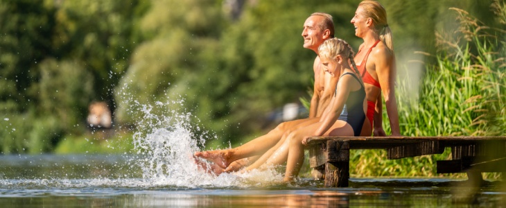 a family sits on the dock of a lake