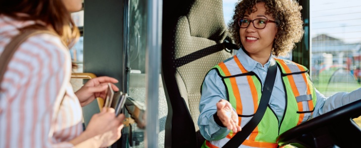 bus driver speaks with a passenger as they climb onboard